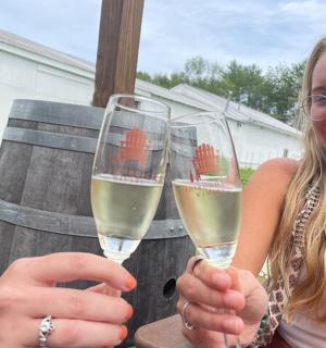 two women holding up glasses of white wine