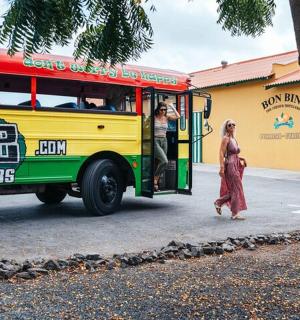 a yellow and green bus with people getting off