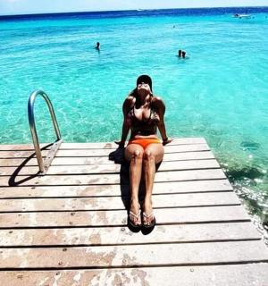 a woman sitting on a dock in the water