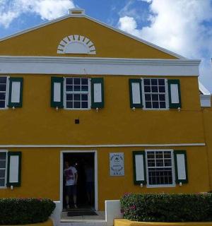 a yellow house with two flags in front of it