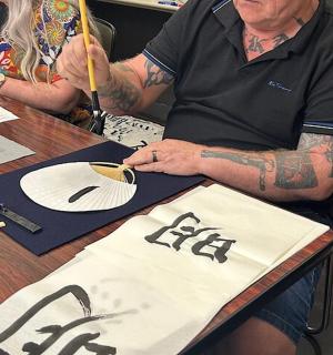 一位手臂上有纹身的男士坐在桌边