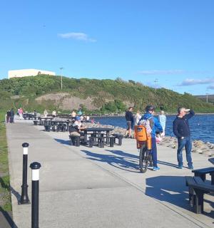 一群人站在水边的人行道上