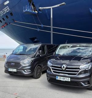 dvě vozidla zaparkovaná vedle velké lodi