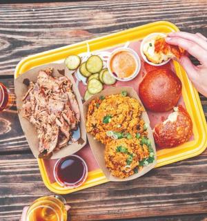 tác s jídlem na stole a osoba, která jí tác s jídlem