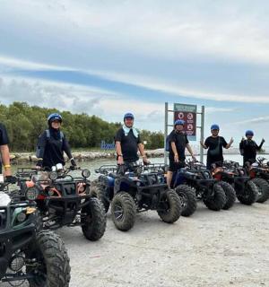 a group of people standing in front of atvs