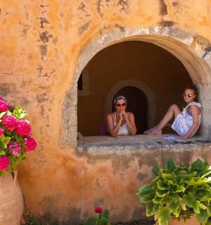 两个女人坐在摆满鲜花的窗台上