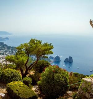 socha ženy stojící na kopci s výhledem na oceán