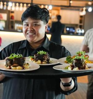 un home sosté un plat de menjar