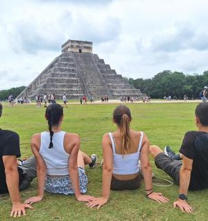 a group of people sitting in front of a pyramid