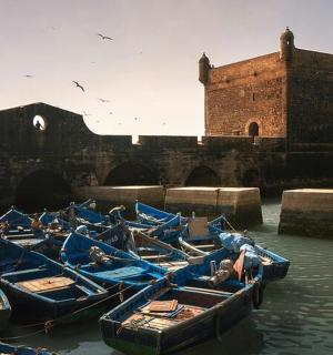 建筑物旁边水中的一组蓝色小船