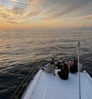 a group of people sitting on a boat in the ocean