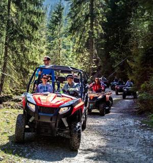 a group of people riding atvs on a dirt road