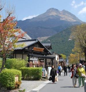 a group of people walking down a street with a mountain