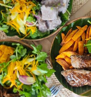 a table with three plates of food and a salad