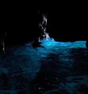 a dark cave with blue water in it