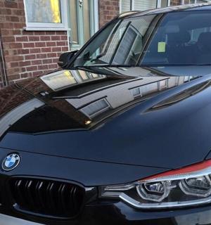 a black car parked next to a brick building