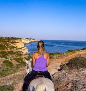 一位女子在海边的悬崖上骑马