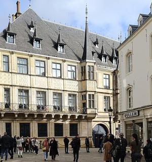 eine Gruppe von Menschen, die vor einem Gebäude spazieren gehen