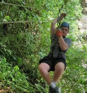 a man riding on a zip line in the jungle