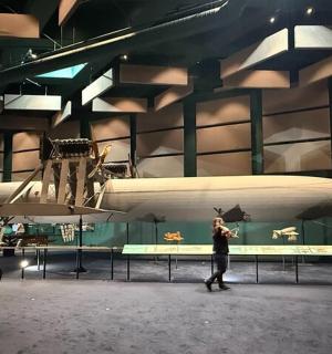 two people standing on a stage with a boat on the wall