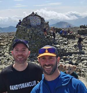 two men standing on top of a rocky mountain