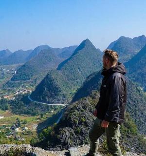 一名男子站在山顶俯瞰山谷