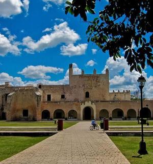 an old castle with a person riding a bike in front
