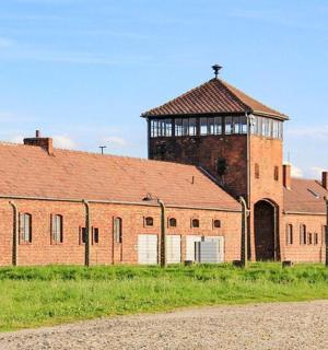 一座大型砖砌建筑，背景是一座水塔