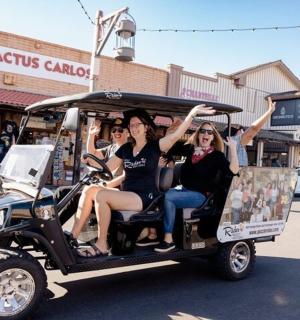 a group of people sitting in a golf cart