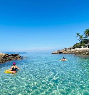 dva lidé kajakují v čisté vodě ostrova