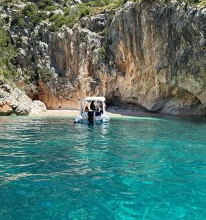 a boat in the water next to a cliff