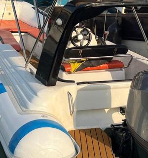 a white boat sitting in the water with a dock