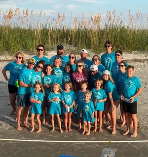 a group of people posing for a picture on the beach