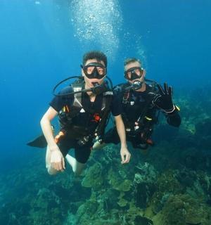 two men in scuba gear swimming in the ocean