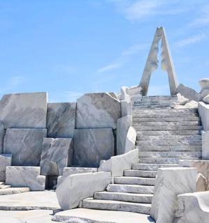 velký kamenný monument s mužem sedícím na vrcholu