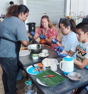 a group of people standing around a table preparing food