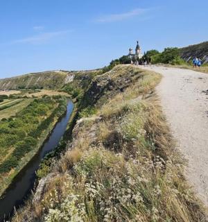 a dirt road next to a river on a hill