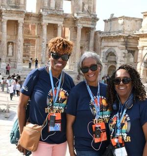 three people standing in front of the coliseum