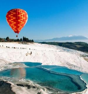 a hot air balloon flying over a beach