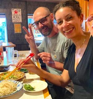 a man and a woman sitting at a table eating food