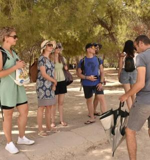 a group of people standing on a sidewalk with an umbrella