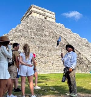 a group of people standing in front of a pyramid