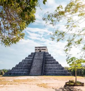 a pyramid in the middle of a park with trees