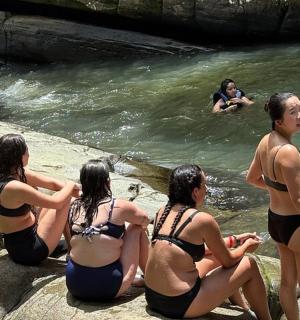 un grup de persones assegudes sobre roques a l'aigua
