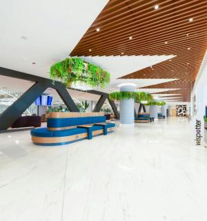 a lobby with chairs and potted plants in a building