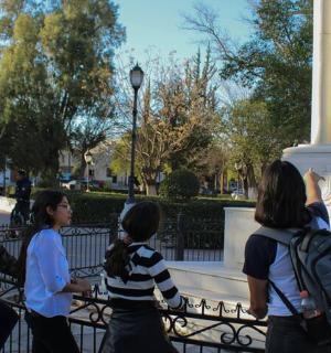 um grupo de pessoas em pé ao redor de um monumento