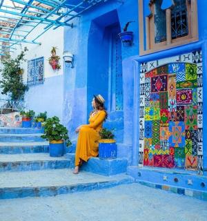 žena stojící před modrou budovou