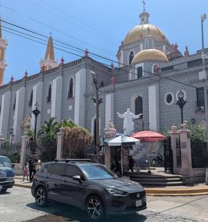 a black car parked in front of a church