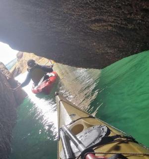 一个人在洞穴水中划皮艇