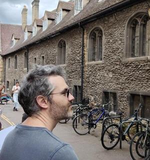 一群人站在一栋建筑外面,骑着自行车